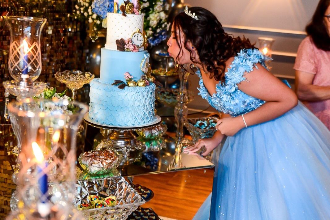 Debutante soprando velas em bolo azul